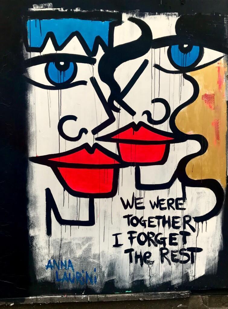 a vibrant image of street art in Dublin which includes two faces and the text "We were together. I forget the rest."