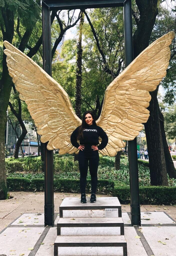 an image of Avi Hakhamanesh posing in front of the Angle of Independence Wings sculpture in Thailand