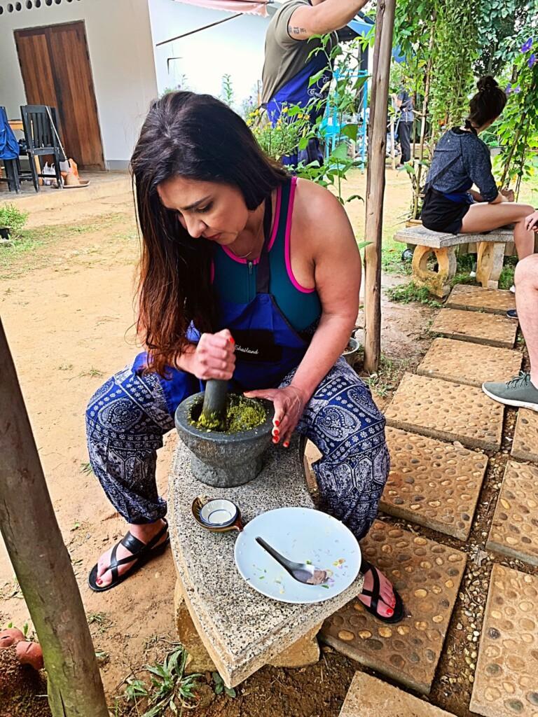 an image of Avi Hakhamanesh grinding spaces as a participant in an outdoor cooking class in Thailand